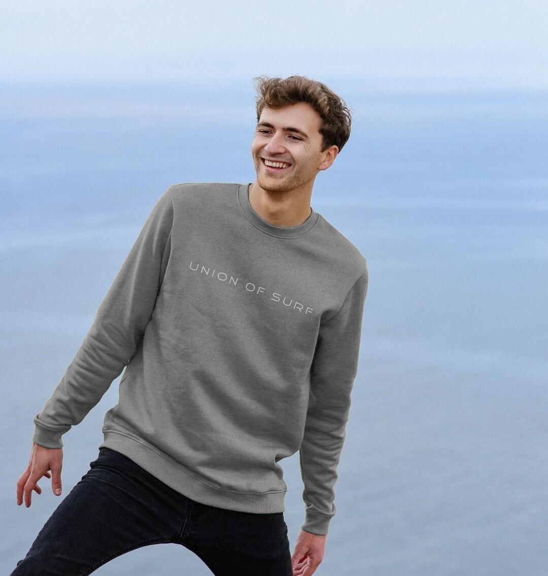 Model wearing Relaxed Fit Coastal Sweatshirt on a coastal hike, showcasing casual coastal style