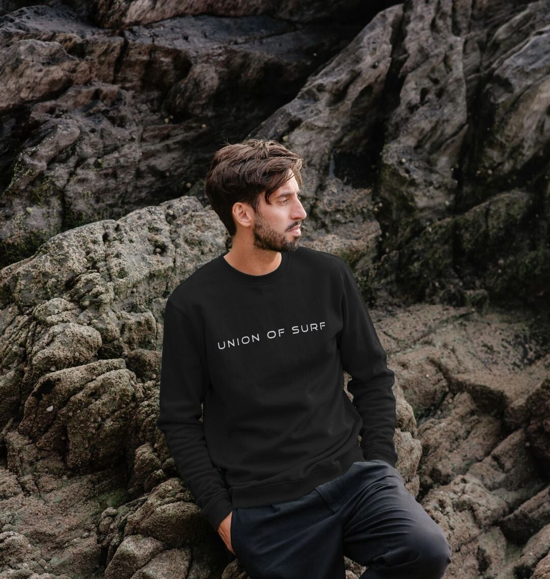 Model wearing Relaxed Fit Coastal Sweatshirt by the ocean, showcasing casual coastal style
