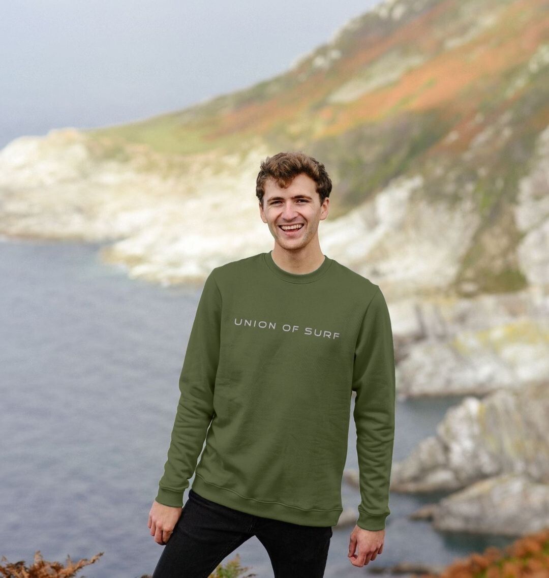 Model wearing Relaxed Fit Coastal Sweatshirt by the ocean, showcasing casual coastal style