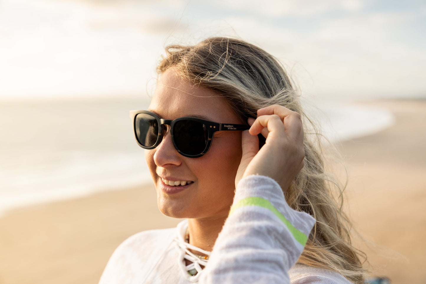 Shaka Black-Daughters of the Sea sunglasses with black sandalwood frames and polarized lenses on the beach
