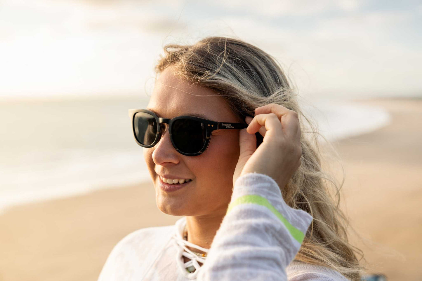 Shaka Black-Daughters of the Sea sunglasses with black sandalwood frames and polarized lenses on the beach