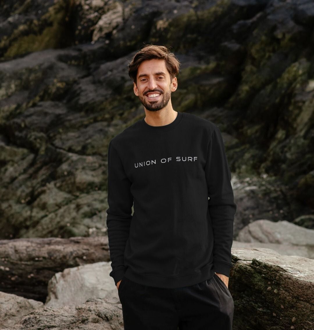 Model wearing Relaxed Fit Coastal Sweatshirt by the ocean, showcasing casual coastal style
