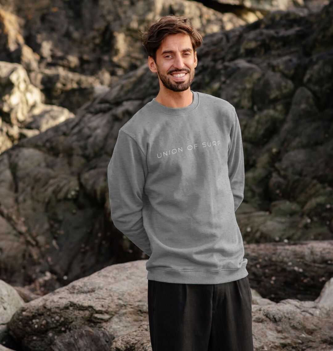 Model wearing Relaxed Fit Coastal Sweatshirt by the ocean, showcasing casual coastal style