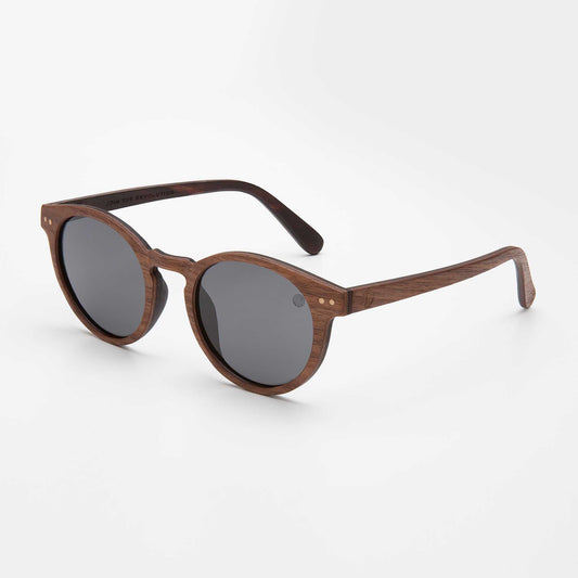 Polarised sunglasses reducing glare on reflective water surface with vibrant scenery background