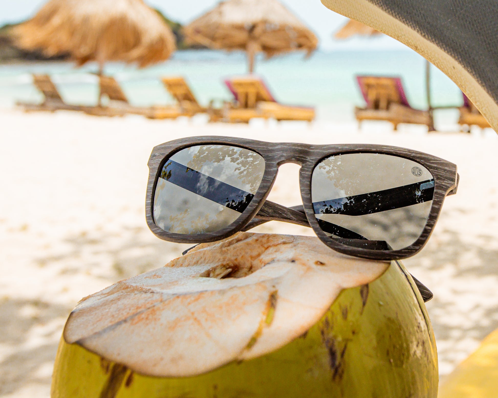 Unisex Sunglasses made from black wood, with polarised lenses. Photographed on a beach in Indonesia