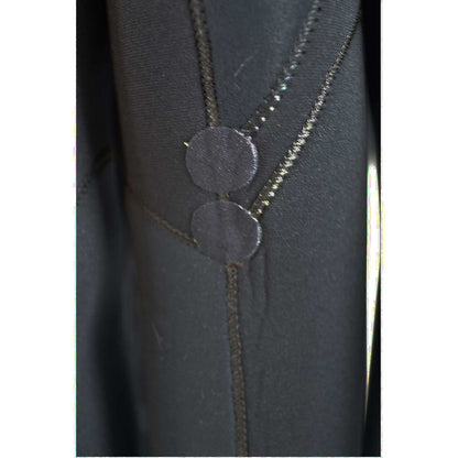 Kids’ back-zip wetsuit in black neoprene, ARC 5/4mm KIDS, with reinforced seams and circular zip guards.