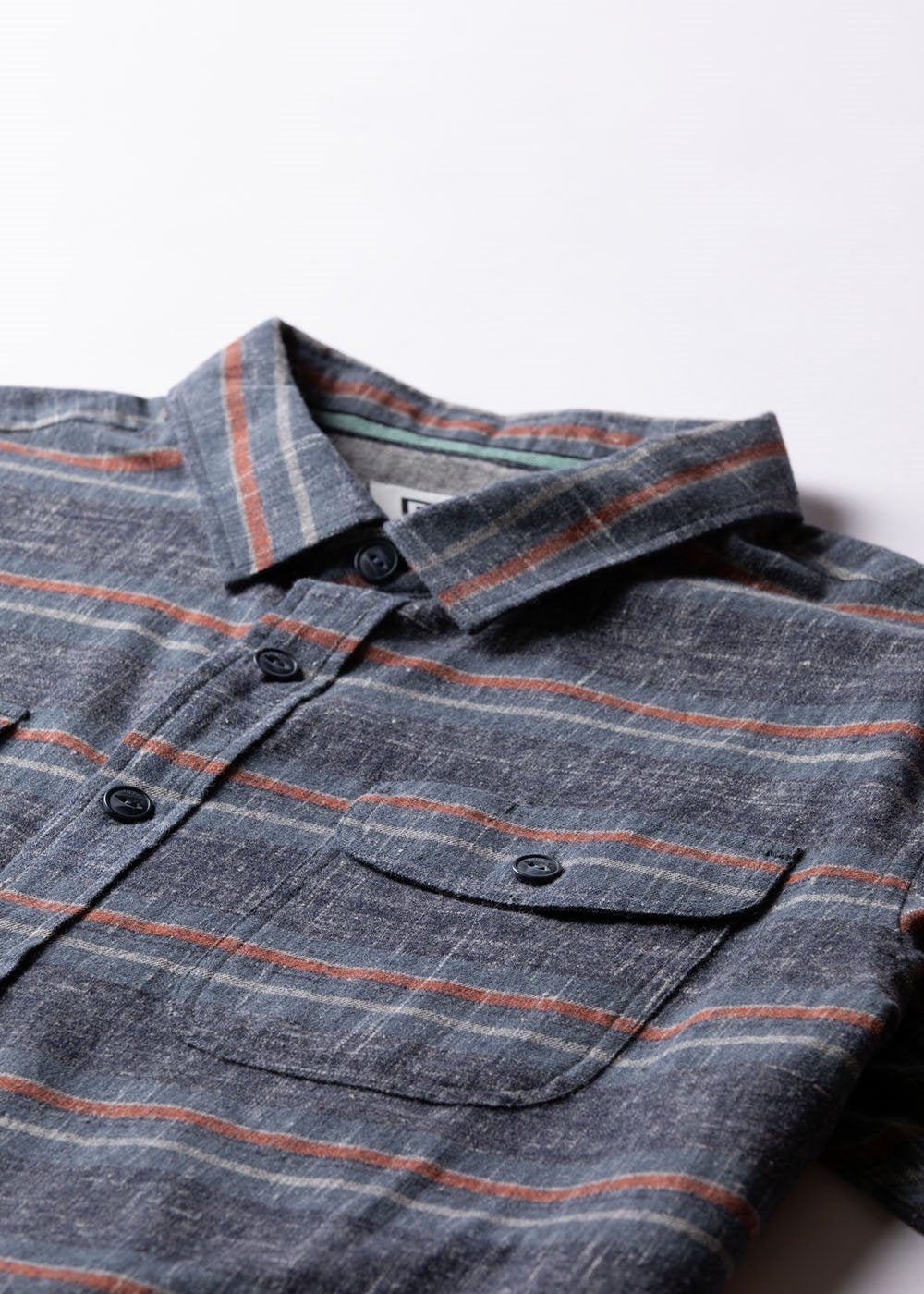 Vissla Central Coast Eco Flannel shirt in charcoal grey plaid, with thin rust stripes, a button front and chest pocket.