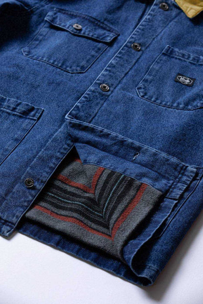 Vissla Peterson Jacket in blue cotton canvas, with buttoned chest pockets, a corduroy collar and patterned wool lining.