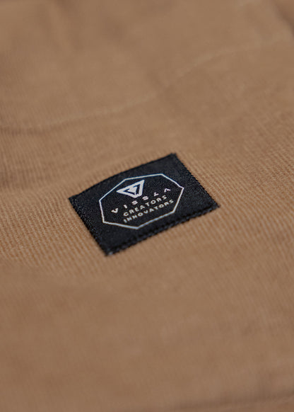 Vissla Paxon Jacket in tan corduroy, featuring a black rectangular brand patch with white logo embroidery.