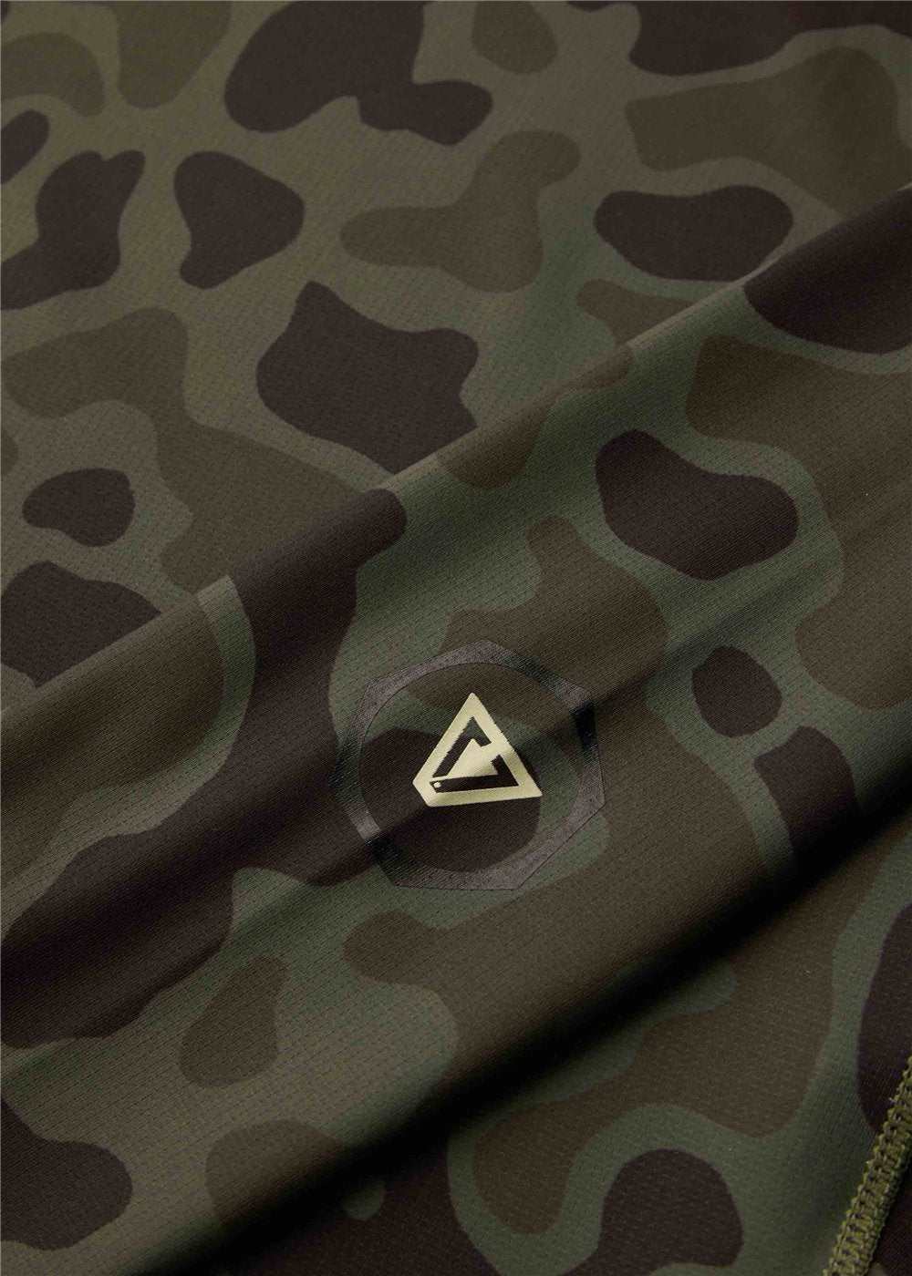 Hooded Lycra rash guard with a dark olive and black camouflage pattern, smooth stretch fabric and a small chest logo; Vissla Warm Seas.