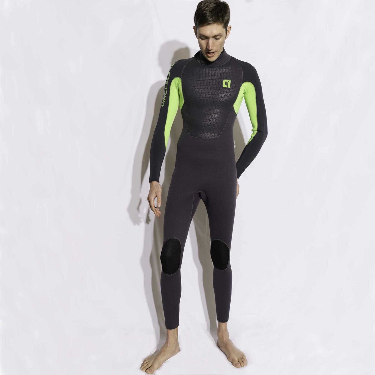Mens 4/3mm Spring Wetsuit in black neoprene with bright green panels, a high neck, long sleeves and reinforced knee patches.