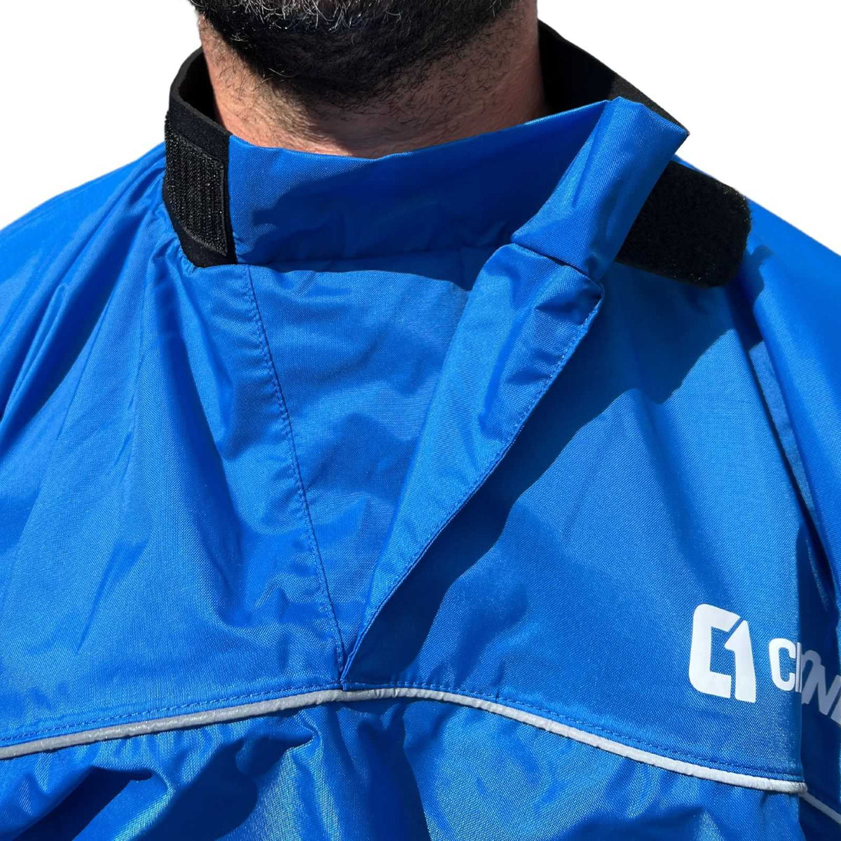 Blue nylon Spray Jacket with a high adjustable collar, black hook-and-loop tabs and reflective trim across the chest.