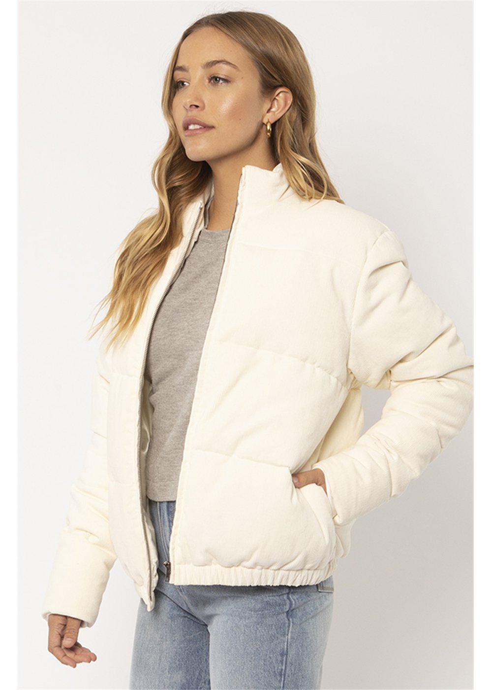 Sisstrevolution Bells Jacket in cream quilted fabric, featuring a stand collar, front zip, and elasticated hem.
