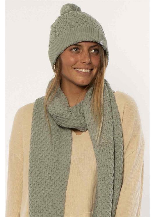 Sisstrevolution Fantasy Beanie in sage green knit with a ribbed brim and matching pom-pom atop the crown.