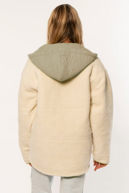 Sisstrevolution Sublime Ls Wvn Jacket in cream faux sherpa with an olive quilted hood and rounded hem, shown from the back.