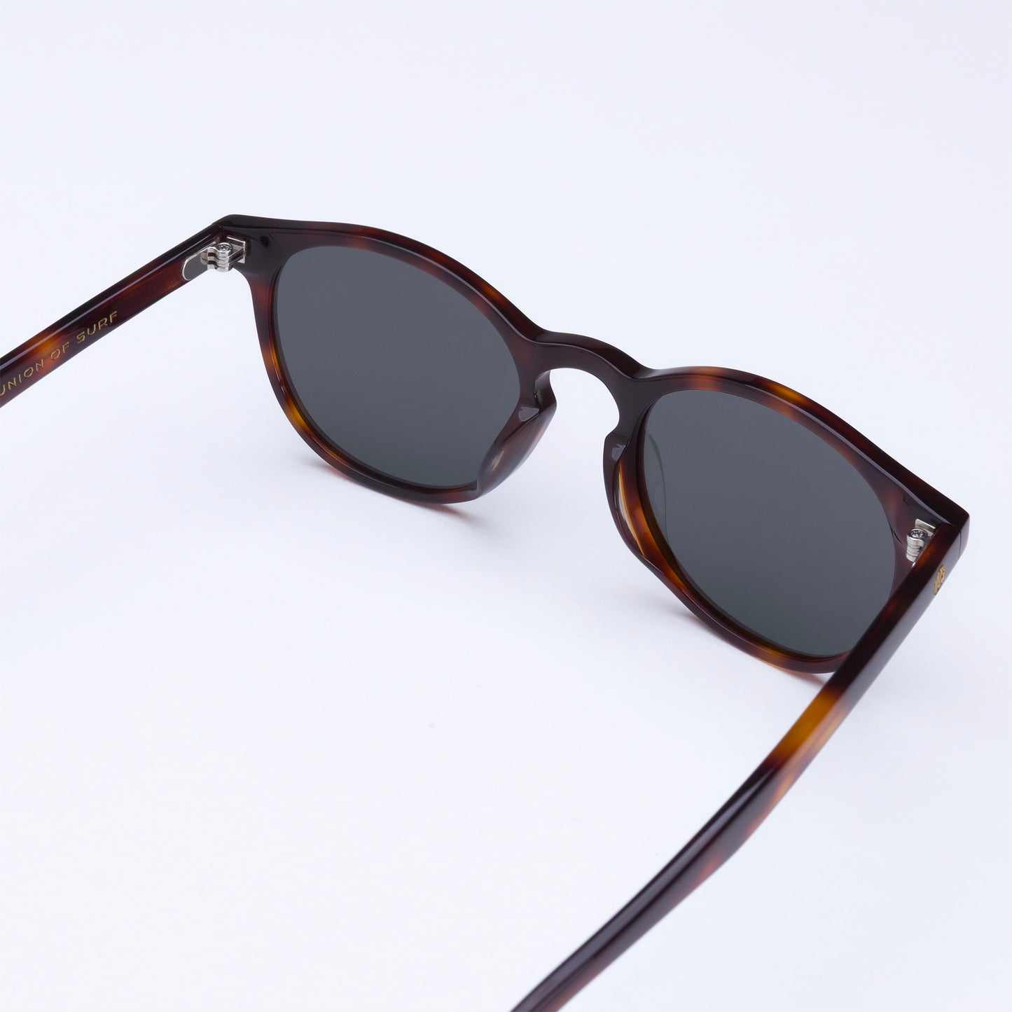 Sunglasses with tortoiseshell frame and dark lenses on a white background
