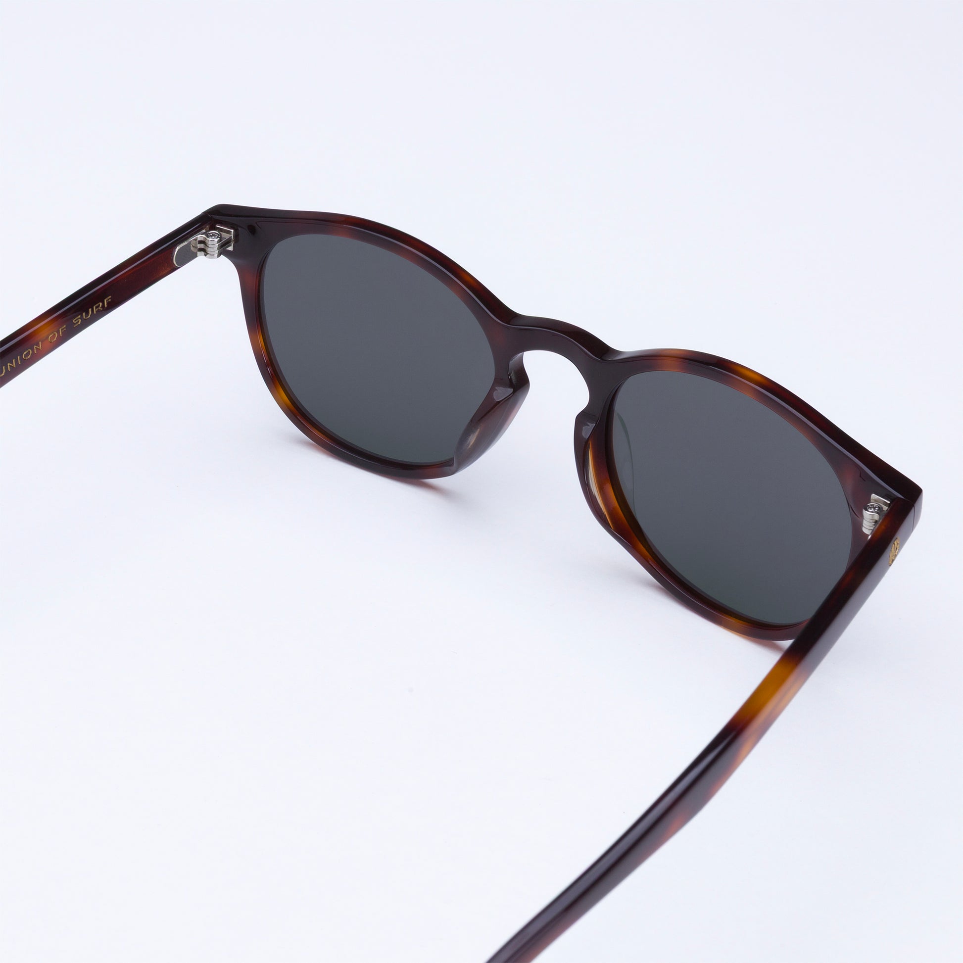 Sunglasses with tortoiseshell frame and dark lenses on a white background